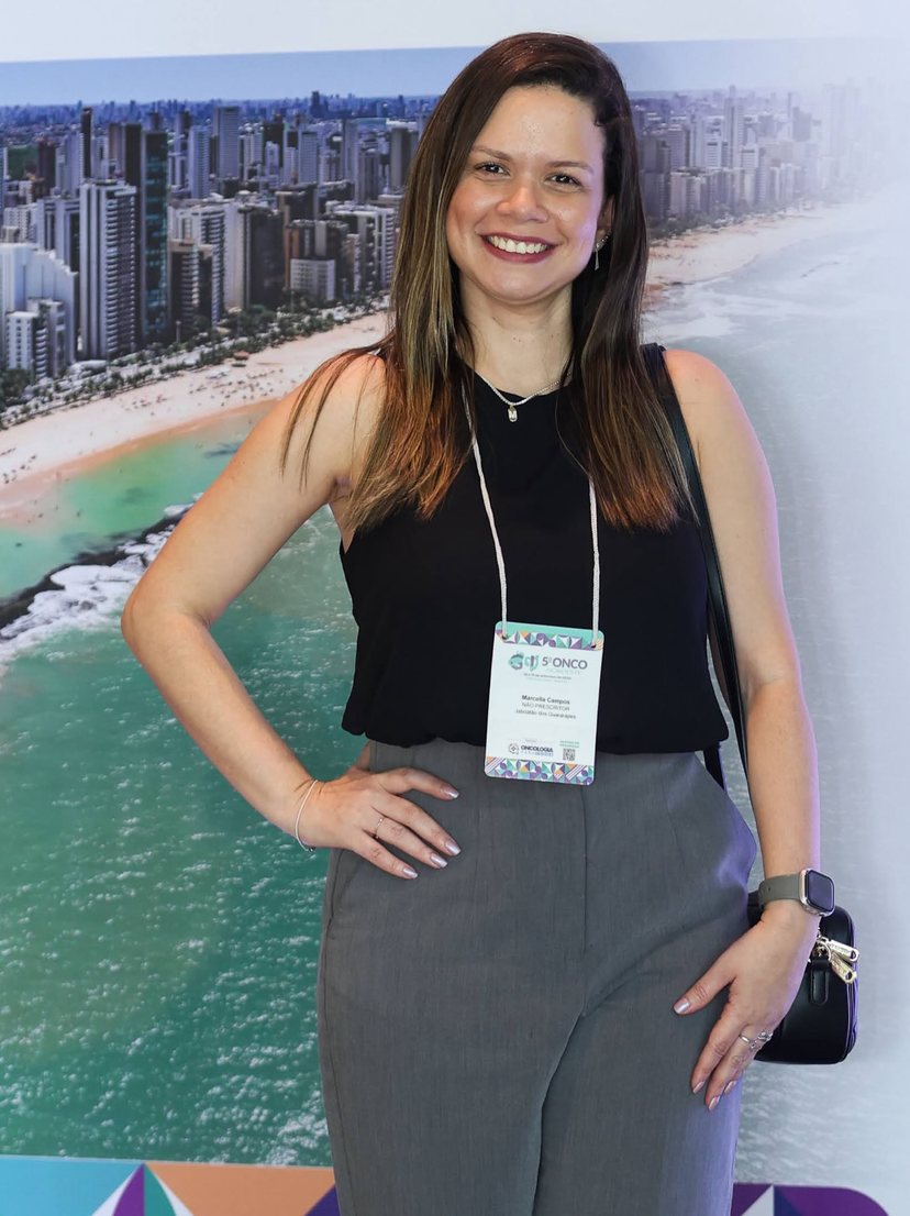 Marcella Campos sorrindo no 5º Onco Nordeste, congresso de oncologia em Recife